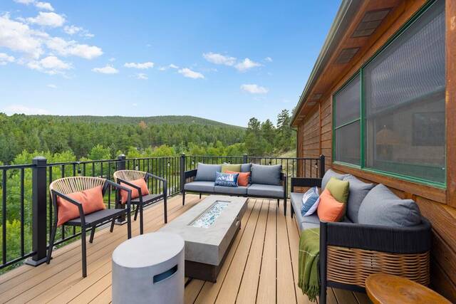 The upper deck, with the propane fire table, lounge seating and the valley beyond