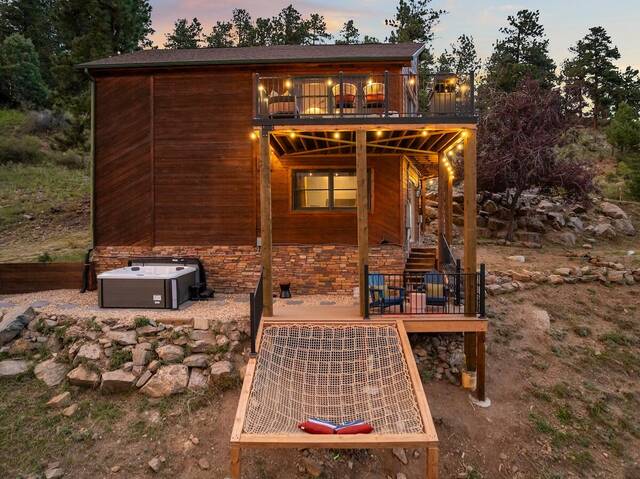 The cabin at dusk from below, with the stargazing net strung beneath the deck