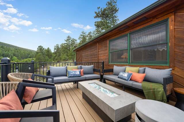 Deck seating around the lit fire table, looking out over the valley