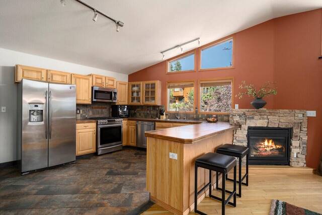 The kitchen, with island seating and a stone fireplace