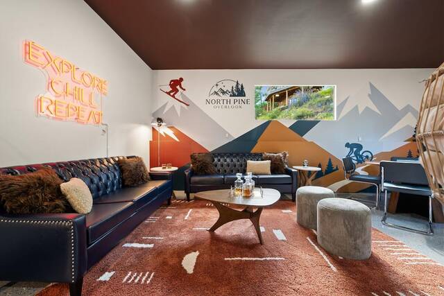 The garage lounge, with its neon Explore Chill Repeat sign and mountain mural