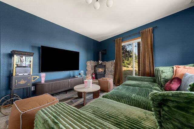 The theater lounge, with a sectional, wood stove and popcorn machine