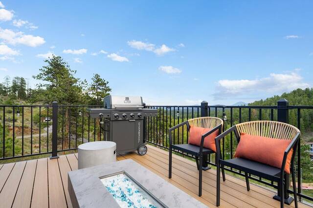 The upper deck, with a gas grill, fire table and seating under open sky