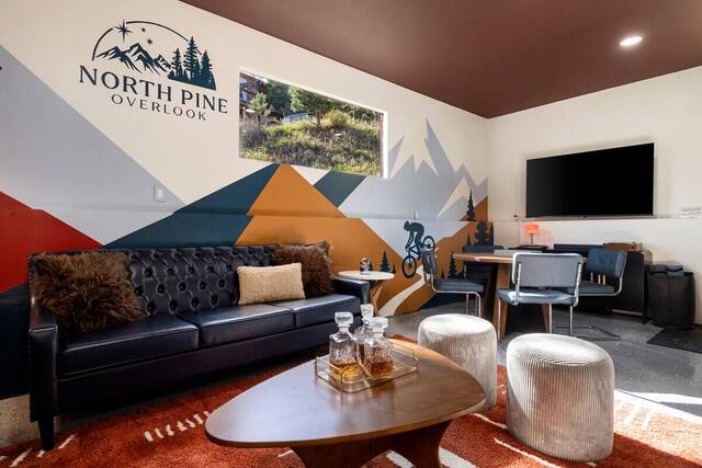 The lounge, with the North Pine Overlook logo wall and a chesterfield sofa
