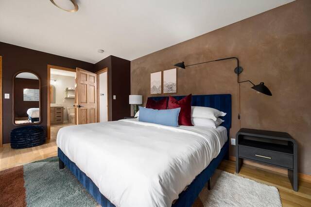 A king bedroom with an upholstered headboard and an ensuite bathroom