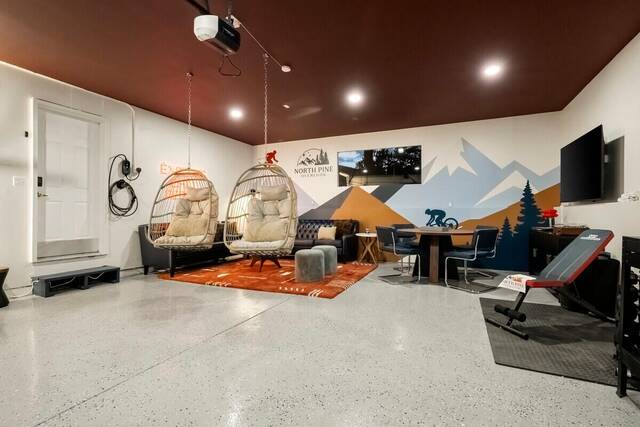 The lounge from the doorway, with hanging egg chairs and the mural wall