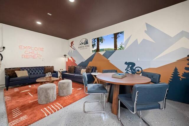 The mural wall, leather sofa and ottomans in the lounge
