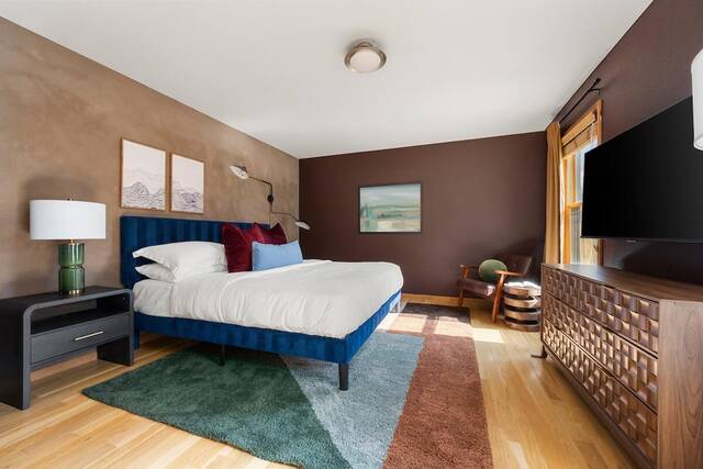 A bedroom with a blue bed frame and wall-mounted television