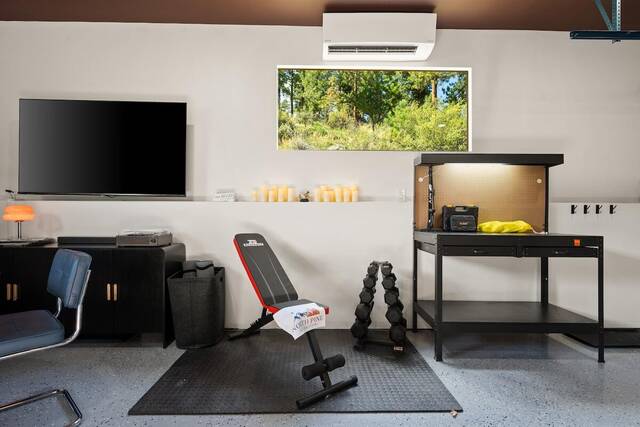 The garage gym, with a weight bench, dumbbells and workbench